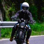 A motorcyclist skillfully maneuvers a bike on a picturesque winding road, wearing a safety helmet., tags: die - pexel