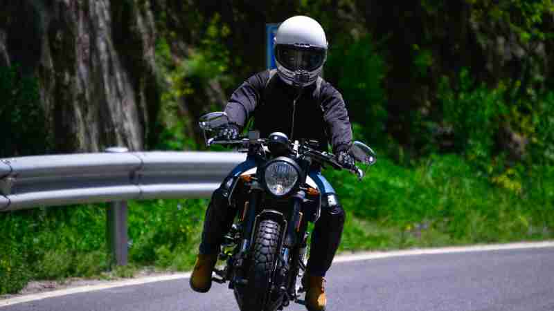 A motorcyclist skillfully maneuvers a bike on a picturesque winding road, wearing a safety helmet., tags: die - pexel